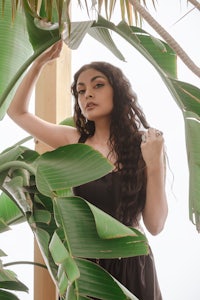 a woman in a black dress posing in a banana leaf