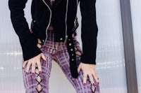 a woman wearing plaid pants and a black jacket