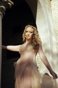 a woman in a dress posing in front of a building