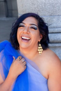 a woman in a blue dress is smiling