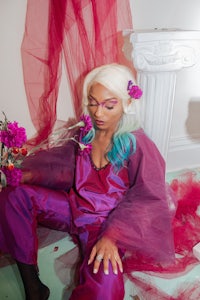 a woman in a purple outfit sitting on the floor