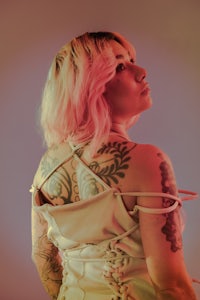 a woman in a white dress with tattoos