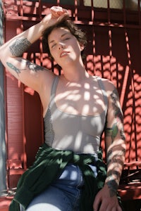 a woman with tattoos sitting on a bench